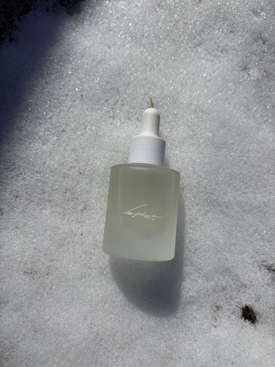 雪の上に置かれた香水瓶